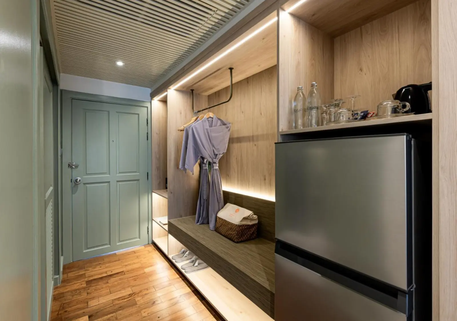 Kleiderschrank- und Mini-Kühlschrankbereich im Zimmer von La Solaya Khao Lak