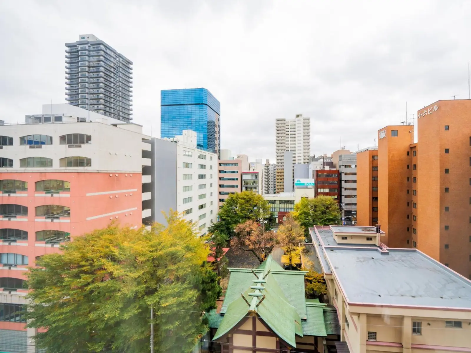 Otra vista de la ciudad desde Sapporo View Hotel Odori Park, mostrando edificios y árboles